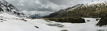 Panoramabild Eisbedeckter Bergsee im Frühling