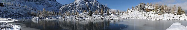 Big panorama picture of mountain lake and the first snow